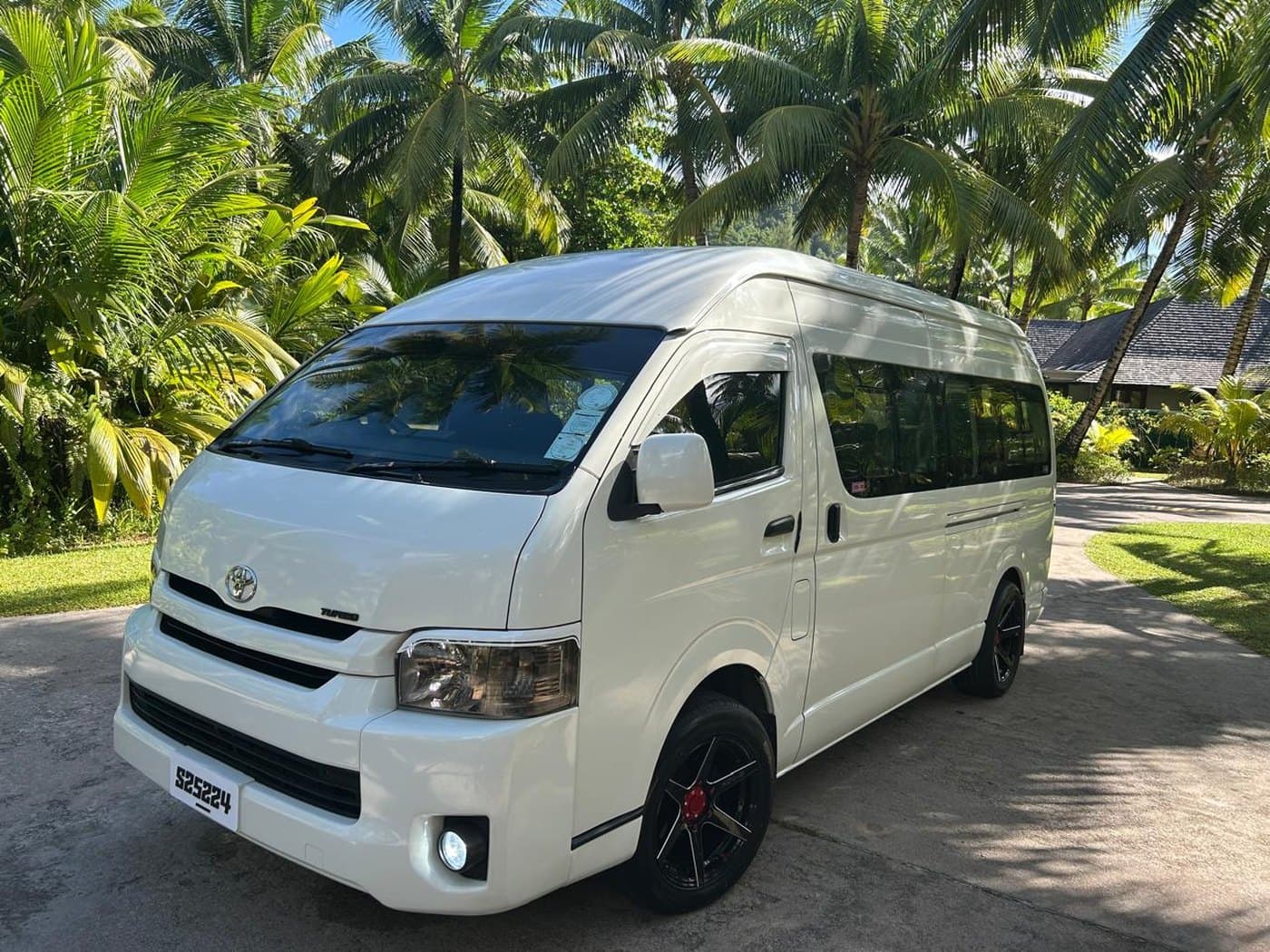 The Toyota Hiace, white with a high roof, parked under palms on Mahé